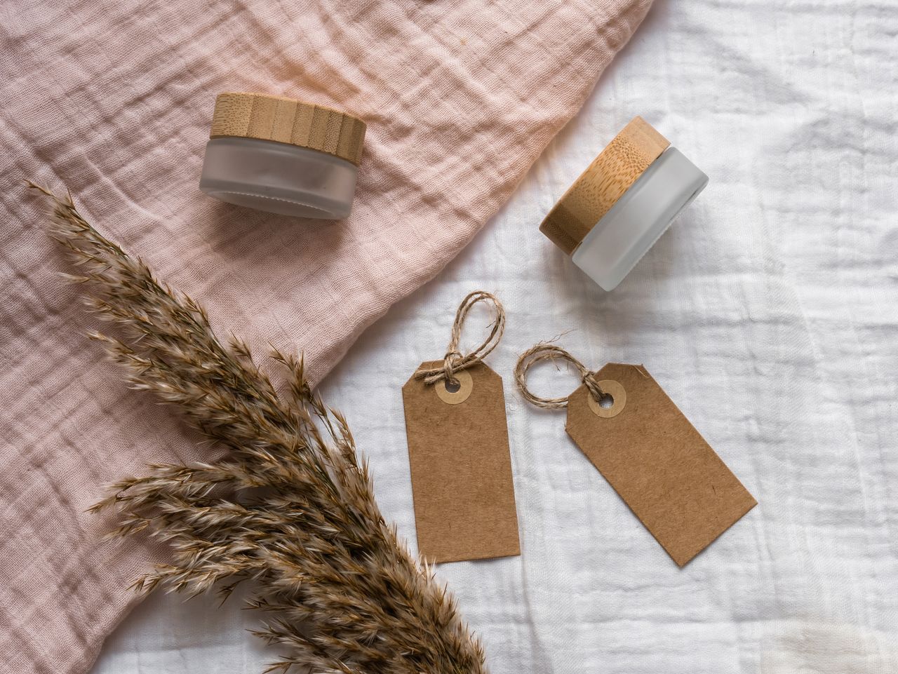 services-01 A rustic flat lay showcasing jars with wooden lids and eco-friendly gift tags arranged on textured fabric. Perfect for branding.